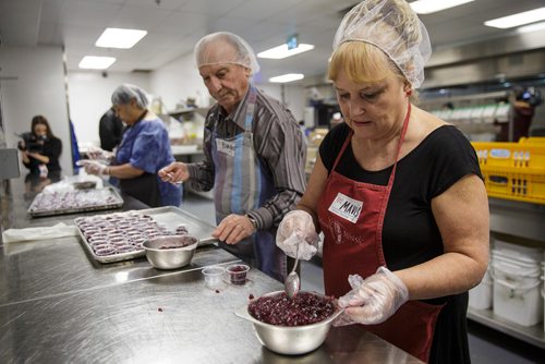 MIKE DEAL / WINNIPEG FREE PRESS
The Siloam Mission Christmas Eve meal serves over 600 people with anywhere from 65-100 volunteers to help make it happen on Monday December 24, 2018.
Volunteers Biagio DeDominicis (left) and Mavis Swedlo (right) prepare the cranberry sauce just before service starts at noon.
181224 - Monday, December 24, 2018.