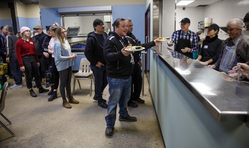 MIKE DEAL / WINNIPEG FREE PRESS
The Siloam Mission Christmas Eve meal serves over 600 people with anywhere from 65-100 volunteers to help make it happen on Monday December 24, 2018.
Jerry Daniels, Grand Chief of the Southern Chiefs' Organization, picks up a couple of plates to serve to community members.
181224 - Monday, December 24, 2018.