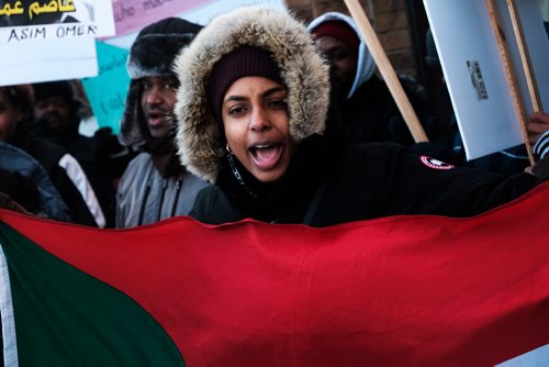 Daniel Crump / Winnipeg Free Press
 Sahaiba Ahmed (left) shouts a chant while holding a sudanese flag as she takes part in a protest outside MP Jim Carrs office (611 Corydon Ave.) in solidarity with the recent protests in Sudan. 
December 28, 2018.