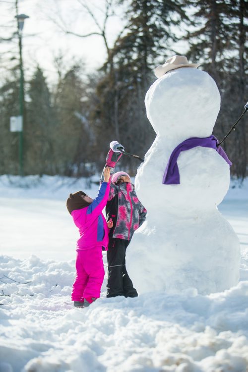 MIKAELA MACKENZIE / WINNIPEG FREE PRESS
Gabrielle (three) and Amelia (five) Happychuk try to high five the snowman they made with their dad at St. Vital Park in Winnipeg on Thursday, Jan. 3, 2019. 
Winnipeg Free Press 2018.