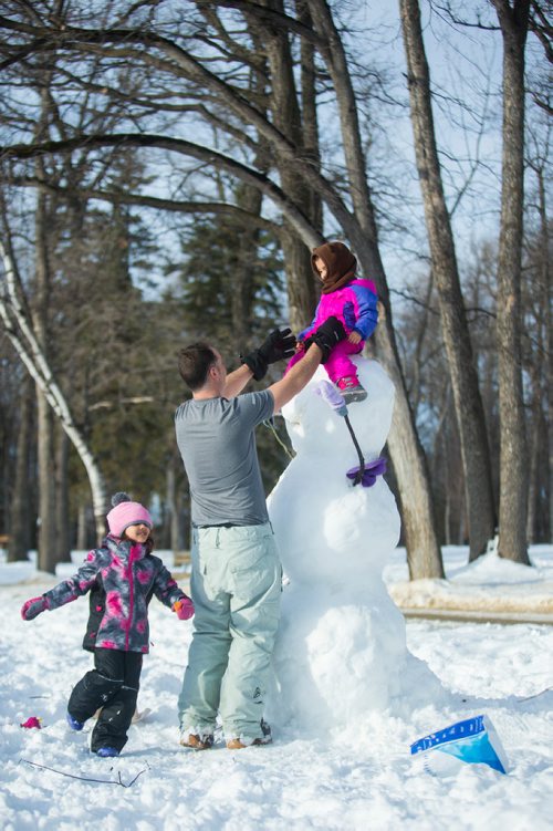 MIKAELA MACKENZIE / WINNIPEG FREE PRESS
Brock Happychuk puts his daughter, Gabrielle (three) on top of the snowman they built while his other daughter, Amelia (five) runs around at St. Vital Park in Winnipeg on Thursday, Jan. 3, 2019. 
Winnipeg Free Press 2018.