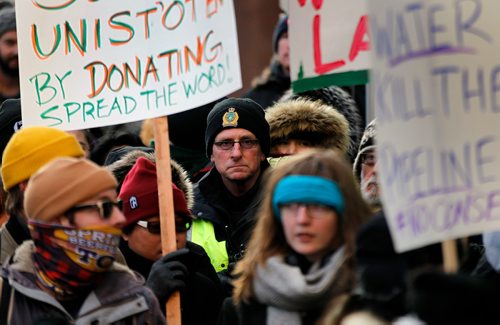 PHIL HOSSACK / WINNIPEG FREE PRESS - A Winnipeg city police officer is surrounded by the thousand or more crowd gatered at Portage and Main Thursday. See Kevin Rollason's story. January 10, 2019