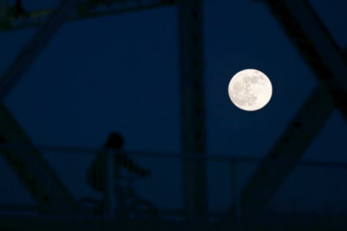 JOHN WOODS / WINNIPEG FREE PRESS
A large moon is seen as a cyclist rides by on the Redwood Bridge in Winnipeg  Sunday, January 20, 2019. A total eclipse of the moon (Blood Moon) will be seen tonight in Winnipeg at 11:12pm.