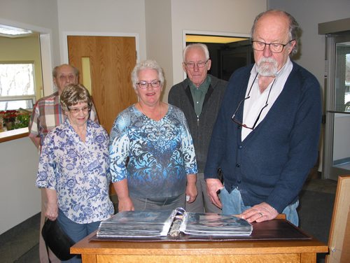 Canstar Community News Jan. 16, 2019 - St. Francois Xavier Historical Society members (from left) Ed and Jean Owchar, Levina Cunningham, Rudy Friesen and Keven Van Camp look at the album filled with photos of local veterans from the First and Second World Wars and the Korean War. (ANDREA GEARY/CANSTAR COMMUNITY NEWS)