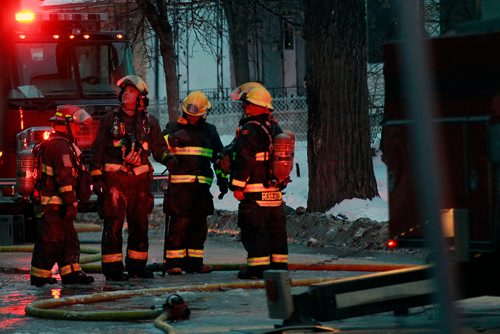 PHIL HOSSACK / WINNIPEG FREE PRESS - City firefighters gaze up at a three story apartment building during a mop up operation Monday. A second fire in the building in a week closed Maryland Street during the afternoon rush hour.-January 21, 2019. 

Note Also I photographed another serious fire at the same location a year maybe 2 ago......not sure of the date, there were injuries then and photos of at least one being taken away.