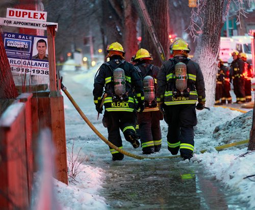 PHIL HOSSACK / WINNIPEG FREE PRESS - City firefighters wade through slush towards a three story apartment building during a mop up operation Monday. A second fire in the building in a week closed Maryland Street during the afternoon rush hour.-January 21, 2019. 

Note Also I photographed another serious fire at the same location a year maybe 2 ago......not sure of the date, there were injuries then and photos of at least one being taken away.