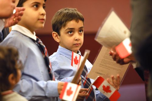 RUTH BONNEVILLE / WINNIPEG FREE PRESS

LOCAL STDUP 

Ramzy George Ramzy Awad Gerges (correct spelling), looks up at officials handing him and his older brother Philopater George Ramzy Awad Gerges, their Canadian citizenship documents after being sworn in at a Citizenship ceremony with their parents held at The VIA Rail Station in Winnipeg Tuesday.  

He was 1 of  84 new citizens from 25 different countries who were sworn in on behalf of the Honourable Ahmed Hussen, Minister of Immigration, Refugees and Citizenship, Matt DeCourcey, Parliamentary Secretary Member to the Minister, Tuesday.   

Standup photo 

January 22nd, 2019

