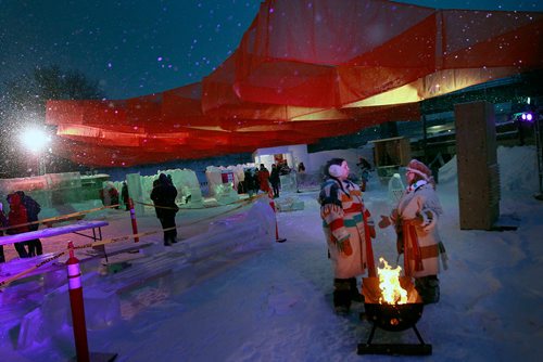PHIL HOSSACK / WINNIPEG FREE PRESS - Mona Moquin and Gisele Brunec  dressed in their voyageur finest keep warm in front of an open fire at the Ice Bar on the Red River Wednesday. See story. January 23, 2019