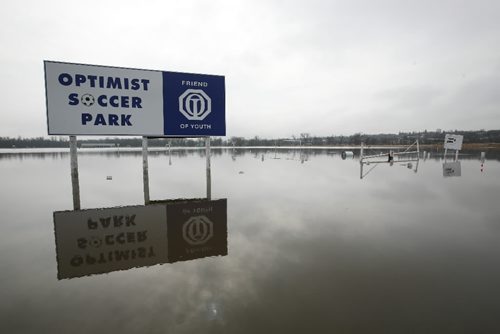 Brandon Sun 13042009 Water from overland flooding makes a lake out of the Optimist Soccer Park bordering 1st St. in Brandon on Monday morning. (Tim Smith/Brandon Sun)
