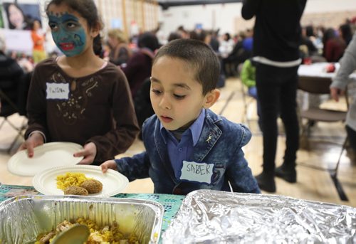 RUTH BONNEVILLE / WINNIPEG FREE PRESS

Story: The Newcomer Community Hub,  located inside Ryerson School, hosts its grand opening Saturday. 

Photo of Saber Hamad (5yrs), checks out the array of traditional ethnic foods at grand opening for the Hub  Saturday.  

Pembina Trails School Division has recently welcomed an increasing number of refugees into its schools. In order to support the community, with a current focus on Yazidi refugees, a unique relationship has been created with Immigration Partnership Winnipeg, the Manitoba Association of Newcomer Serving Organizations and a number of other groups called, The Newcomer Community Hub.   It is located in Ryerson School in Pembina Trails School Division and is a one-stop shop of services that traditionally have been located in the citys downtown.   The Newcomer Community Hub held its formal grand opening with food, activities for kids and ribbon cutting ceremony.  

See Solomon's story. 
 
January 26th,  2019
