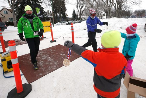 JOHN WOODS / WINNIPEG FREE PRESS
From left, Loic Shearer and Noah Cunningham give medals to their parents Dave and Amanda as they finish the 6th annual Frostbite River Run, a fundraiser in support of programming and activities at Riverview Community Centre in WinnipegSunday, January 27, 2019. The Frostbite River Run is part of the Riverview Winter Classic - a series of outdoor events held in January at the community centre.