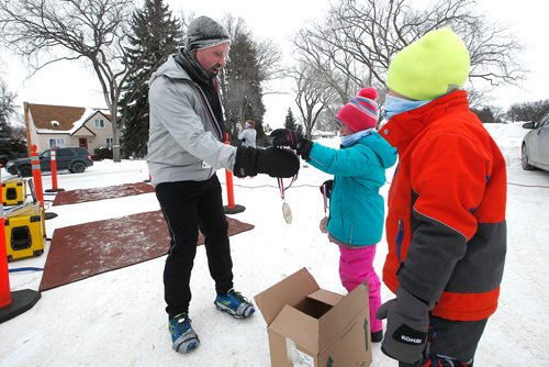 JOHN WOODS / WINNIPEG FREE PRESS
Noah Cunningham gives a medal to Jason Oliver as he finishes the 6th annual Frostbite River Run, a fundraiser in support of programming and activities at Riverview Community Centre in WinnipegSunday, January 27, 2019. The Frostbite River Run is part of the Riverview Winter Classic - a series of outdoor events held in January at the community centre.
