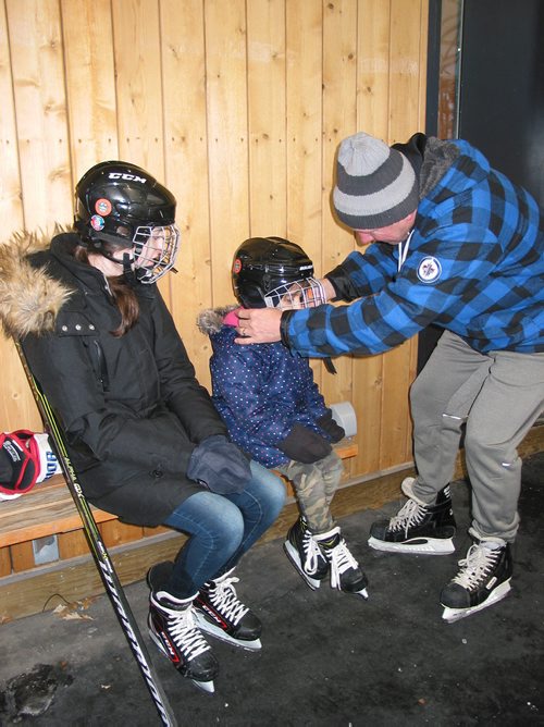 Canstar Community News Jan. 13, 2019 - Camp Manitou staff member and former Winnipeg Jet Thomas Steen helps a youngster put on her helmet before taking to the ice at Camp Manitou on Jan. 13 as part of a newcomer event. (ANDREA GEARY/CANSTAR COMMUNITY NEWS)