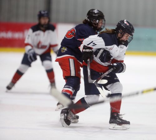 TREVOR HAGAN / WINNIPEG FREE PRESS
Sisters, Central Plains Capitals, Taylor Woodward, age 18, left is hit by St.Mary's Academy Flames' Alexis Woodward, age 15, during the Female World Sport School Challenge hockey tournament at the Iceplex, Thursday, January 31, 2019. It was the first time they have played each other.