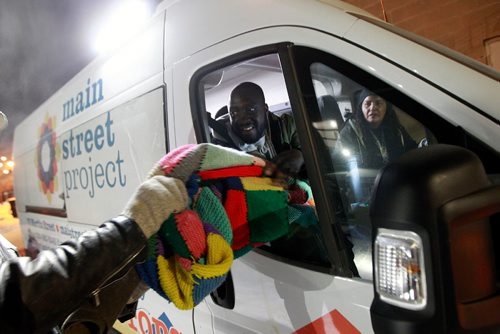 PHIL HOSSACK / WINNIPEG FREE PRESS - Emmanuael Olatubosun hands out a quilted wool blanket know by donors to a man living on the streets Thursday night. January 31, 2019