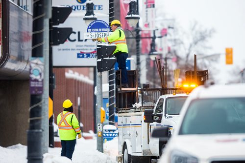 MIKAELA MACKENZIE / WINNIPEG FREE PRESS
City of Winnipeg traffic servicers Sarah Longe (left) and Denis Bouchard put up the honourary street sign to recognize the Festival du Voyageurs 50th anniversary at St. Joseph St. in Winnipeg on Thursday, Feb. 7, 2019. 
Winnipeg Free Press 2019.