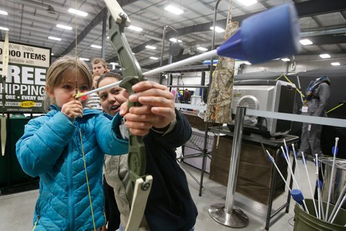 JOHN WOODS / WINNIPEG FREE PRESS
Natasha Moss, with Cabelas, shows five year old Maja Reimer how to shoot a bow and arrow during the Manitoba Outdoors Show at Red River Exhibition Place in Winnipeg Sunday, February 10, 2019.