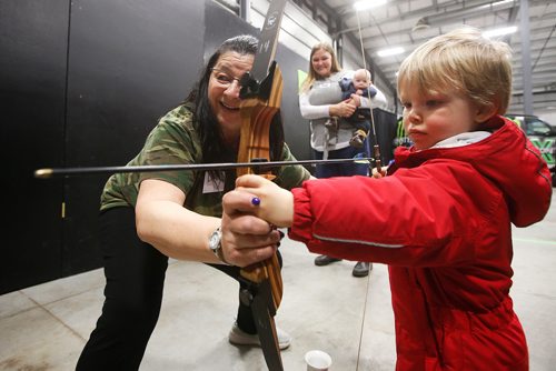 JOHN WOODS / WINNIPEG FREE PRESS
Diane Minion, with Heights Archery Range, shows two year old Ezra Reimer how to shoot a bow and arrow as his mother Amanda and baby brother Levi look on during the Manitoba Outdoors Show at Red River Exhibition Place in Winnipeg Sunday, February 10, 2019.