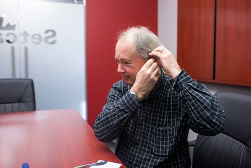 MIKAELA MACKENZIE / WINNIPEG FREE PRESS
Reporter Kevin Rollason puts in earbuds before trying out the SimVoice technology at the Setcan offices in Winnipeg on Friday, Feb. 15, 2019.
Winnipeg Free Press 2019.