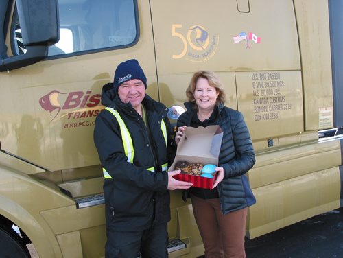 Canstar Community News Feb. 20, 2019 - Bison Transport driver Terence Hollas receives a box of specially designed CentrePort Canada president and CEO Diane Gray. The doughnuts were made and distributed at the Tim's location at 11 Davis way in the RM of Rosser on Feb. 20. (ANDREA GEARY/CANSTAR COMMUNITY NEWS)