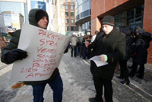 JOHN WOODS / WINNIPEG FREE PRESS
Tom (did not want last name used), left, hands out brochures as he protests the Barrack Obama speech outside a downtown arena Monday, March 4, 2019.