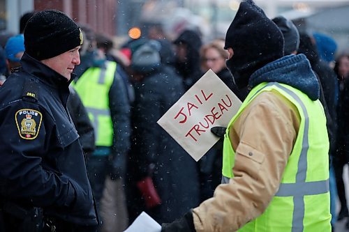 JOHN WOODS / WINNIPEG FREE PRESS
A police office talks to a person, who identified as being connected to Yellow Vests Canada, as he holds a sign as people line up to attend the Barack Obama speech at a downtown arena Monday, March 4, 2019.