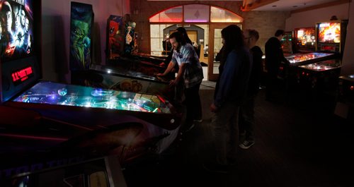 PHIL HOSSACK / WINNIPEG FREE PRESS - Landon Butterorth (in plaid, centre) plays as a group of friends watch at a  Pinball Popup Friday night at the Forks See Declan's story re:Pinball Popup. January 8, 2019.