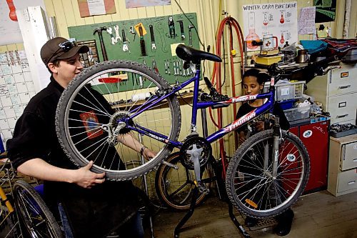 BORIS MINKEVICH / WINNIPEG FREE PRESS 090430 Bike Dump. Volunteer Tyler Markowsky helps 13 year old Thomas Habte fix his bike.