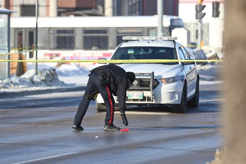 MIKE DEAL / WINNIPEG FREE PRESS
Winnipeg Police Officer seems to be counting shell casings at the scene of a what they are reporting as a homicide on Ellice Avenue between Strathcona Street and Empress Street Tuesday morning. A very large area has been taped off, all the businesses in the JYSK parking lot are closed, the businesses in the Dollar Store parking lot are closed and access to the Residence Inn is closed. 
190312 - Tuesday, March 12, 2019