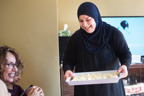 MIKAELA MACKENZIE / WINNIPEG FREE PRESS
Badyra Humsi gives her Canadian friends a taste of her homemade cheese at the Humsi family home in Winnipeg on Tuesday, March 12, 2019. The two families met through a Volunteer Matching Program with the Manitoba Interfaith Immigration Council that pairs Canadians up with newcomers.
Winnipeg Free Press 2019.