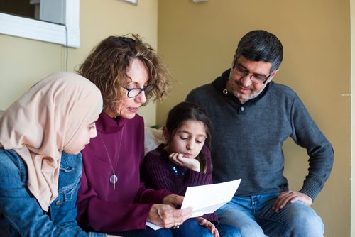 MIKAELA MACKENZIE / WINNIPEG FREE PRESS
Alana Langelotz helps the girls, Shahed (left) and Ghena Humsi, and their dad, Yasser Humsi read their report cards at the Humsi family home in Winnipeg on Tuesday, March 12, 2019. The two families met through a Volunteer Matching Program with the Manitoba Interfaith Immigration Council that pairs Canadians up with newcomers.
Winnipeg Free Press 2019.