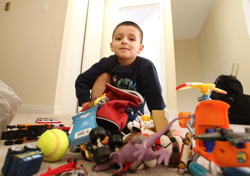 Five-year-old Bewar Zndnam with toys he's received at the family's Winnipeg apartment. Feb.13, 2019. Shannon VanRaes/Winnipeg Free Press