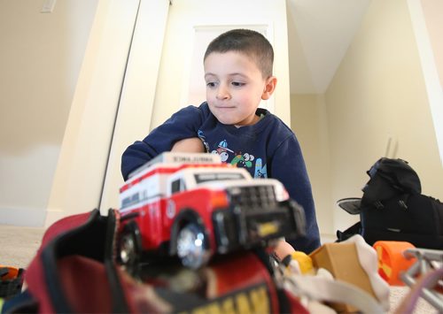 Five-year-old Bewar Zndnam with toys he's received at the family's Winnipeg apartment. Feb.13, 2019. Shannon VanRaes/Winnipeg Free Press