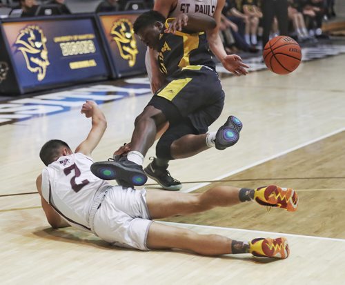 TREVOR HAGAN/ WINNIPEG PRESS
Dakota Lancers Christian Aye trips over St.Pauls Crusaders Zachary Wynne during their semi final high school basketball game at the University of Manitoba, Friday, March 15, 2019.