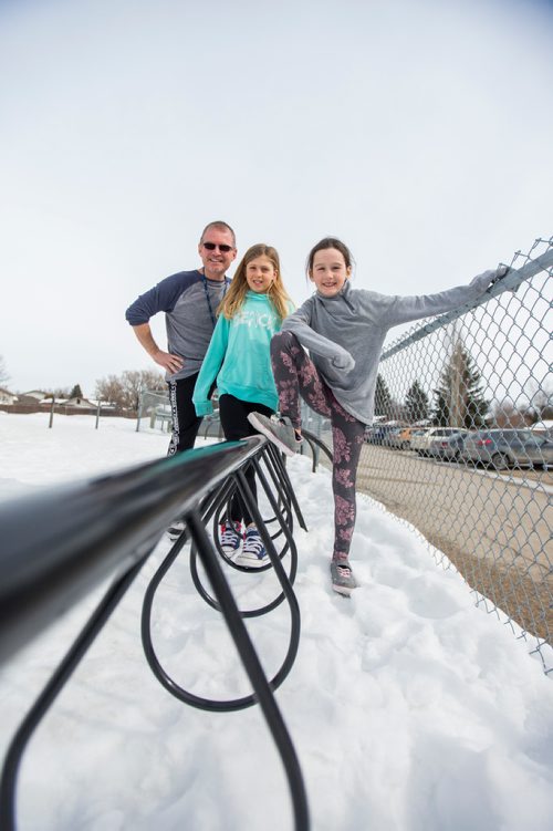 MIKAELA MACKENZIE / WINNIPEG FREE PRESS
Teacher Luc Roy and students Emily (centre) and Isabella pose for a photo at Ecole Sun Valley School with a bike rack they received free of charge last year from the Green Action Centre in Winnipeg on Tuesday, March 19, 2019. 
Winnipeg Free Press 2019.