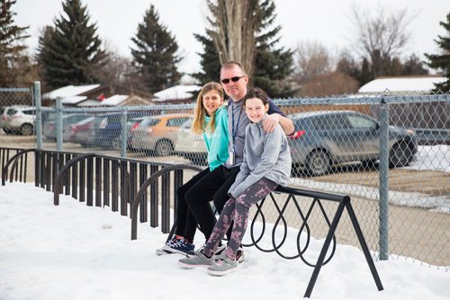 MIKAELA MACKENZIE / WINNIPEG FREE PRESS
Teacher Luc Roy and students Emily (left) and Isabella pose for a photo at Ecole Sun Valley School with a bike rack they received free of charge last year from the Green Action Centre in Winnipeg on Tuesday, March 19, 2019. 
Winnipeg Free Press 2019.