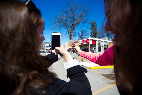 MIKAELA MACKENZIE / WINNIPEG FREE PRESS
Emily Klingbell (left) and Heidi Doelger take pictures of their ice cream on opening day at Bridge Drive In in Winnipeg on Friday, March 22, 2019. 
Winnipeg Free Press 2019.