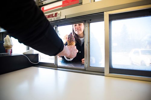 MIKAELA MACKENZIE / WINNIPEG FREE PRESS
Emily Klingbell gets ice cream on opening day at Bridge Drive In in Winnipeg on Friday, March 22, 2019. 
Winnipeg Free Press 2019.