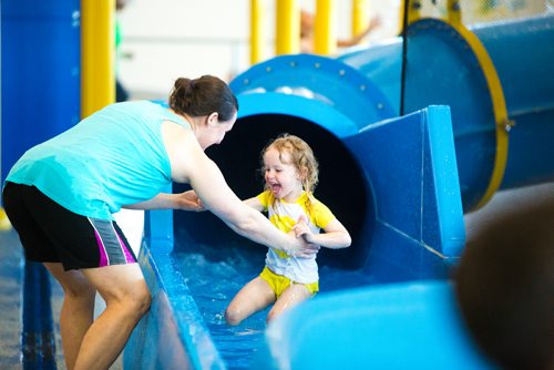 MIKAELA MACKENZIE / WINNIPEG FREE PRESS
Callie Burdy-Osterman, three, gets a helping hand out of the big slide from her mom, Melissa Burdy, at the citys first indoor splash pad at Seven Oaks Pool in Winnipeg on Thursday, March 28, 2019. 
Winnipeg Free Press 2019.