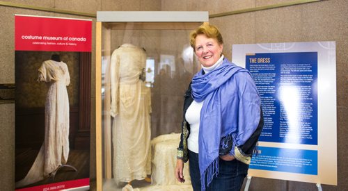 MIKAELA MACKENZIE / WINNIPEG FREE PRESS
Margaret Mills, board member of the Costume Museum, poses for a portrait with the Muriel Richardson dress on display in the Richardson Building in Winnipeg on Monday, April 1, 2019.  For Cassidy Dankochik story.
Winnipeg Free Press 2019.