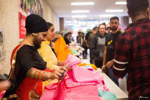 MIKAELA MACKENZIE / WINNIPEG FREE PRESS
Gurkiran Kaur cuts fabric as Red River College students try on turbans for a cultural pride day at the college in Winnipeg on Wednesday, April 3, 2019.  For Alexandra Paul story.
Winnipeg Free Press 2019.