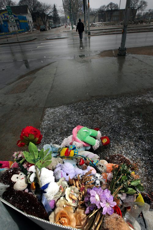 PHIL HOSSACK / WINNIPEG FREE PRESS - A pedestrian makes his way near the memorial for  Galila Barakiel at the crosswalk where she and her mother Genet were struck. The flowers and stuffed animals have been moved from the crosswalk signal post back to a light standard farther away from the street. See Rollason's story.- April 4, 2019.