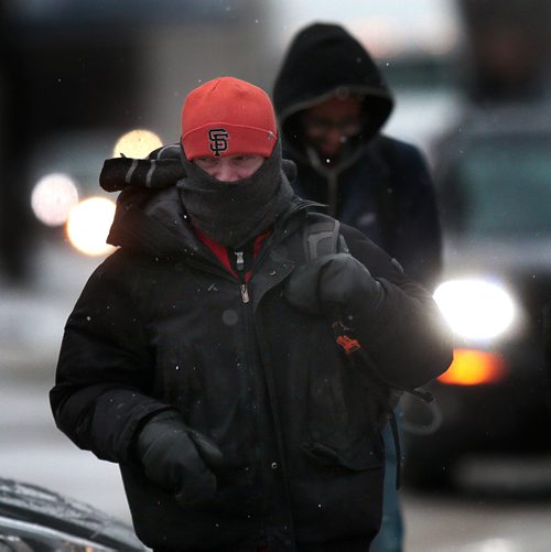 PHIL HOSSACK / WINNIPEG FREE PRESS - Pedestrians brace themselves against a strong south wind as they cross Portage ave near Memorial Thursday. A strong storm front sent rain, snow, sleet and wind to buffet the commute home. STANDUP.- April 4, 2019.
