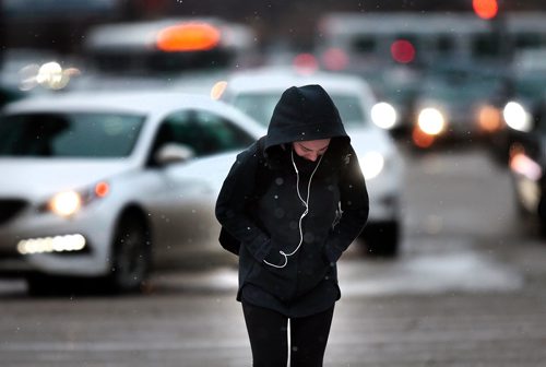 PHIL HOSSACK / WINNIPEG FREE PRESS - Pedestrians brace themselves against a strong south wind as they cross Portage ave near Memorial Thursday. A strong storm front sent rain, snow, sleet and wind to buffet the commute home. STANDUP.- April 4, 2019.