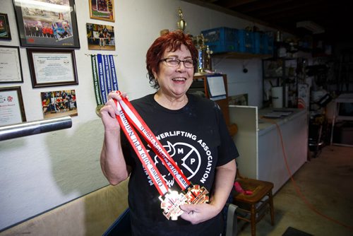 MIKE DEAL / WINNIPEG FREE PRESS
Susan Haywood a record-breaking 70-year-old power lifter with her Nationals medals in her home gym near Teulon, Manitoba.
190403 - Wednesday, April 03, 2019.