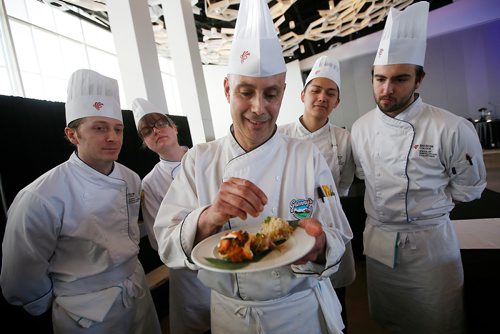 JOHN WOODS / WINNIPEG FREE PRESS
As Red River culinary students look on Chef Jason Wortzman, Granny's Poultry Cooperative, prepares open faced turkey sausage empanada with orange and onion slaw with coconut rice at the Siloam Mission Food Fight in the Convention Centre in Winnipeg Tuesday, April 9, 2019. 
 
Reporter: Standup