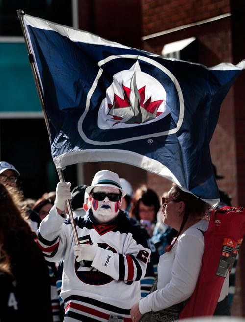 PHIL HOSSACK / WINNIPEG FREE PRESS -  Flag waiving fans wait patiently for the gates to open in the lineup to get into the Jets whiteout street party on Donald Street venue Wednesday. See story. - April 10, 2019.