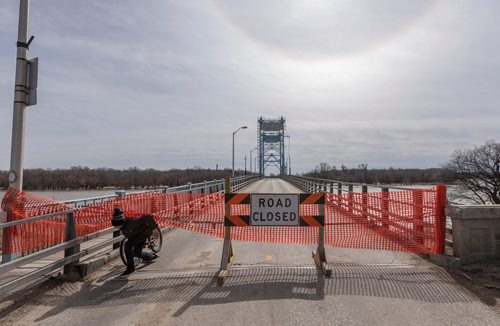 SASHA SEFTER / WINNIPEG FREE PRESS
A cyclist sneaks under a safety barrier blocking access to the Selkirk Bridge. The bridge, which passes over the Red River has been closed due to river waters rising dangerously close to the roadway.
190411 - Thursday, April 11, 2019.