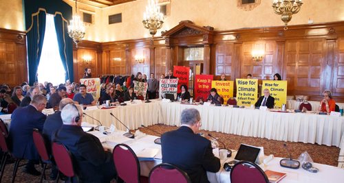 MIKE DEAL / WINNIPEG FREE PRESS
Portestors hold signs behind the lawyers providing testimony for Manitoba Hydro as will a group representing negatively impacted communities during the Bill C-69 Senate hearing at the Fort Garry Hotel Friday morning.
190412 - Friday, April 12, 2019.