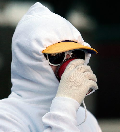 PHIL HOSSACK / WINNIPEG FREE PRESS - WHITE OUT PARTY- One party goer kept the chill away with the hoodie drawn tight and a mug a joe on Smith Street Friday. See Alex Paul's story. - April 12, 2019.